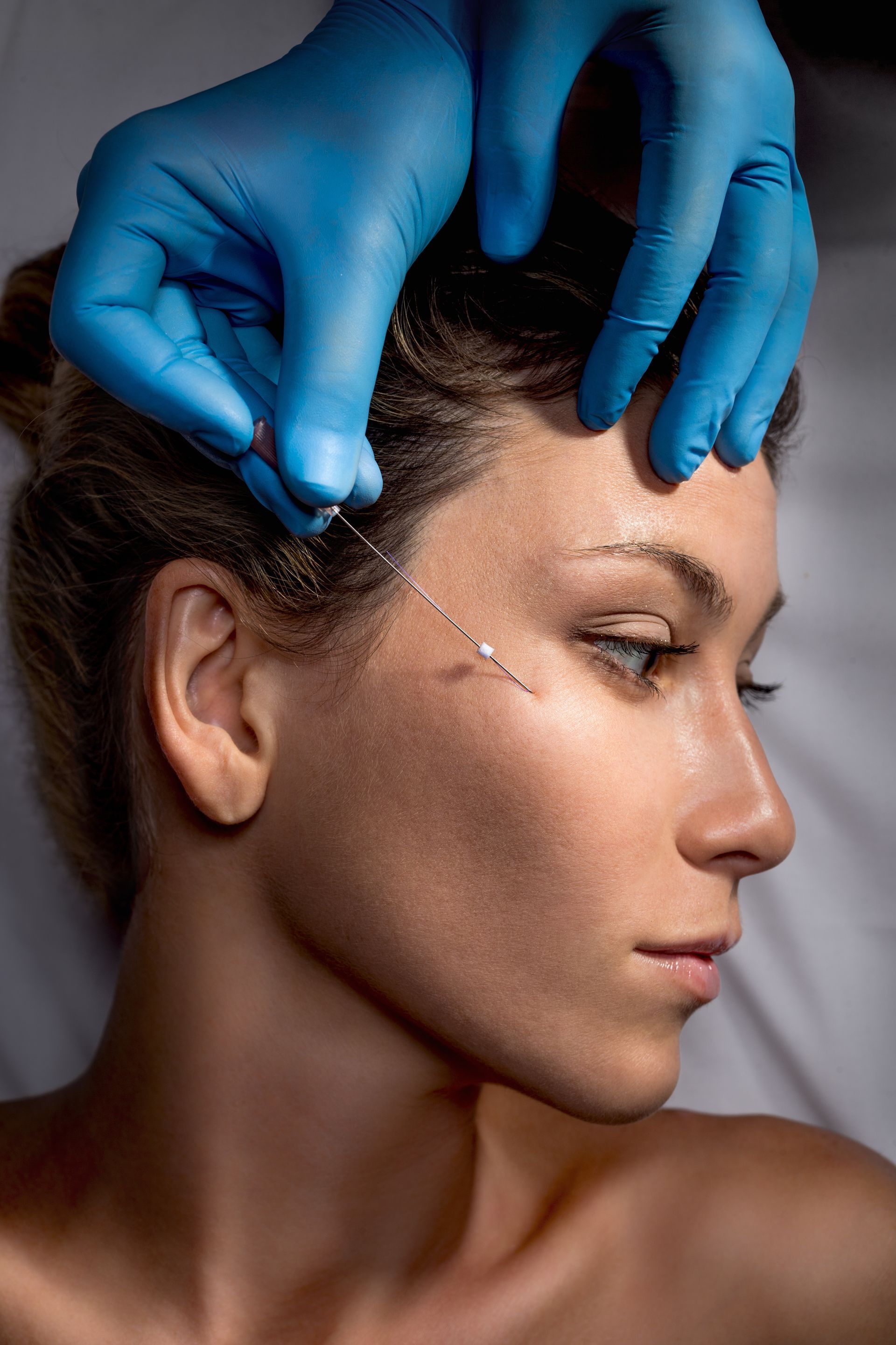 a woman is getting an injection in her face