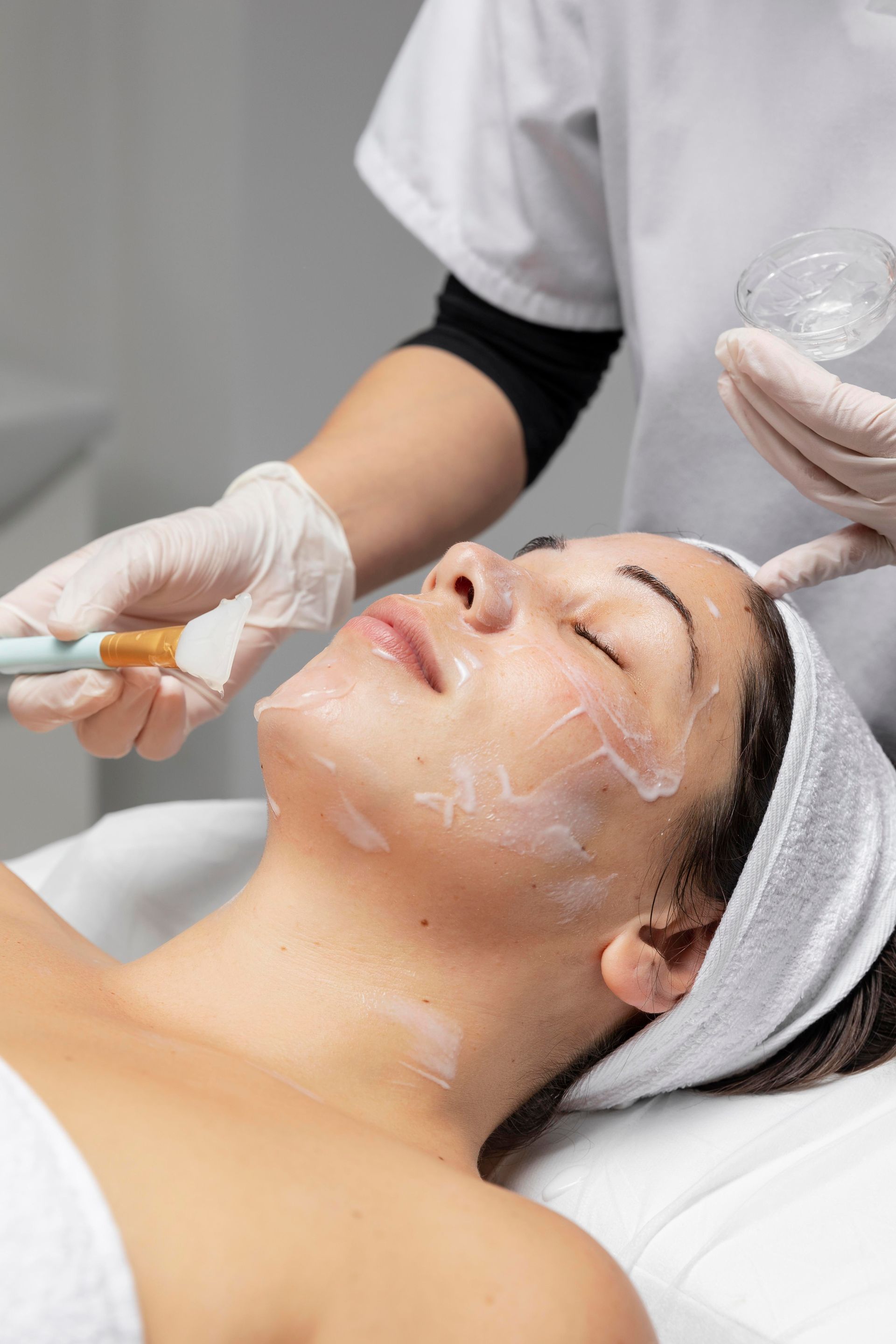 a woman is receiving a facial treatment with a brush