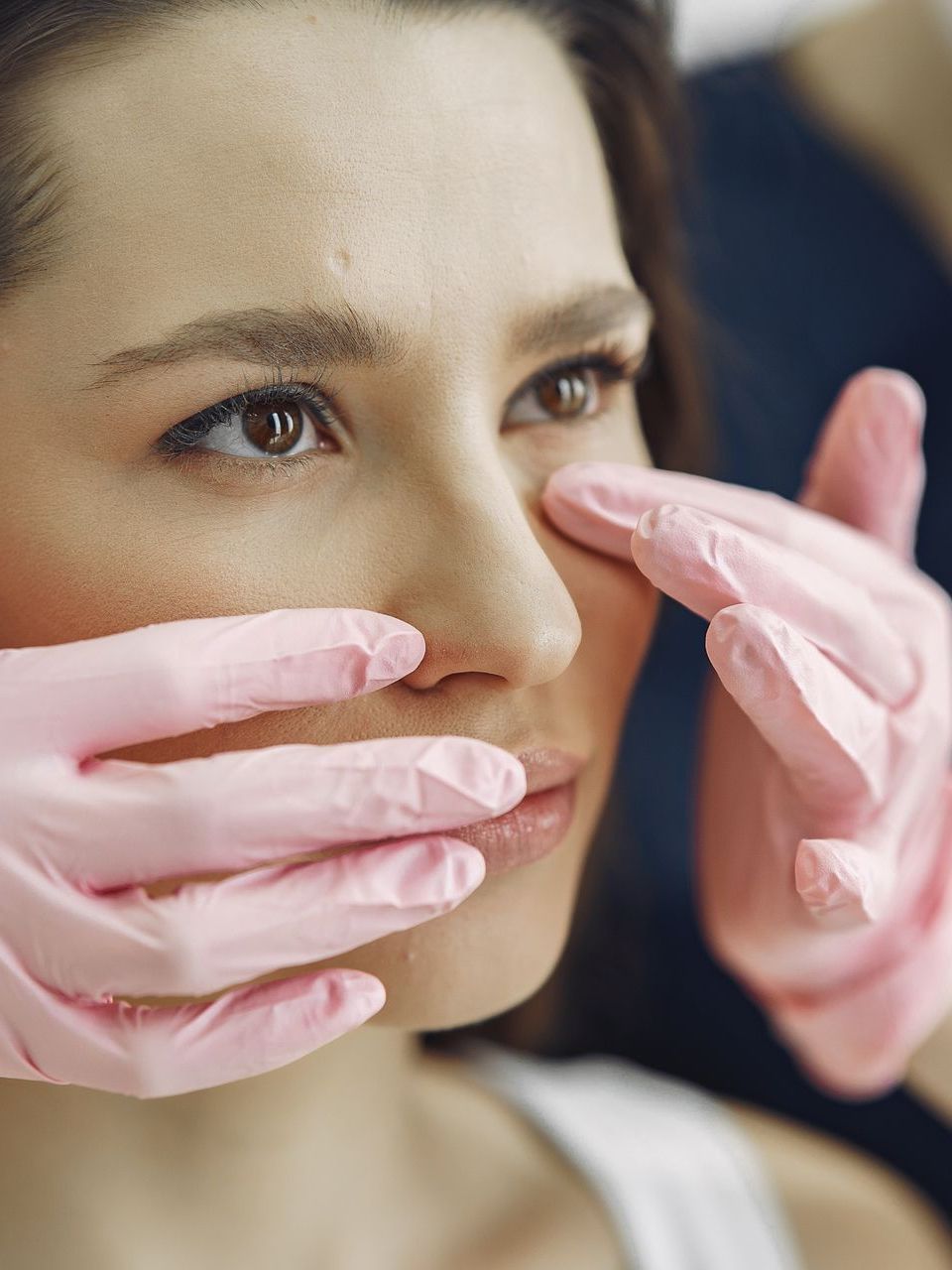a woman in a surgical cap is getting a nose surgery