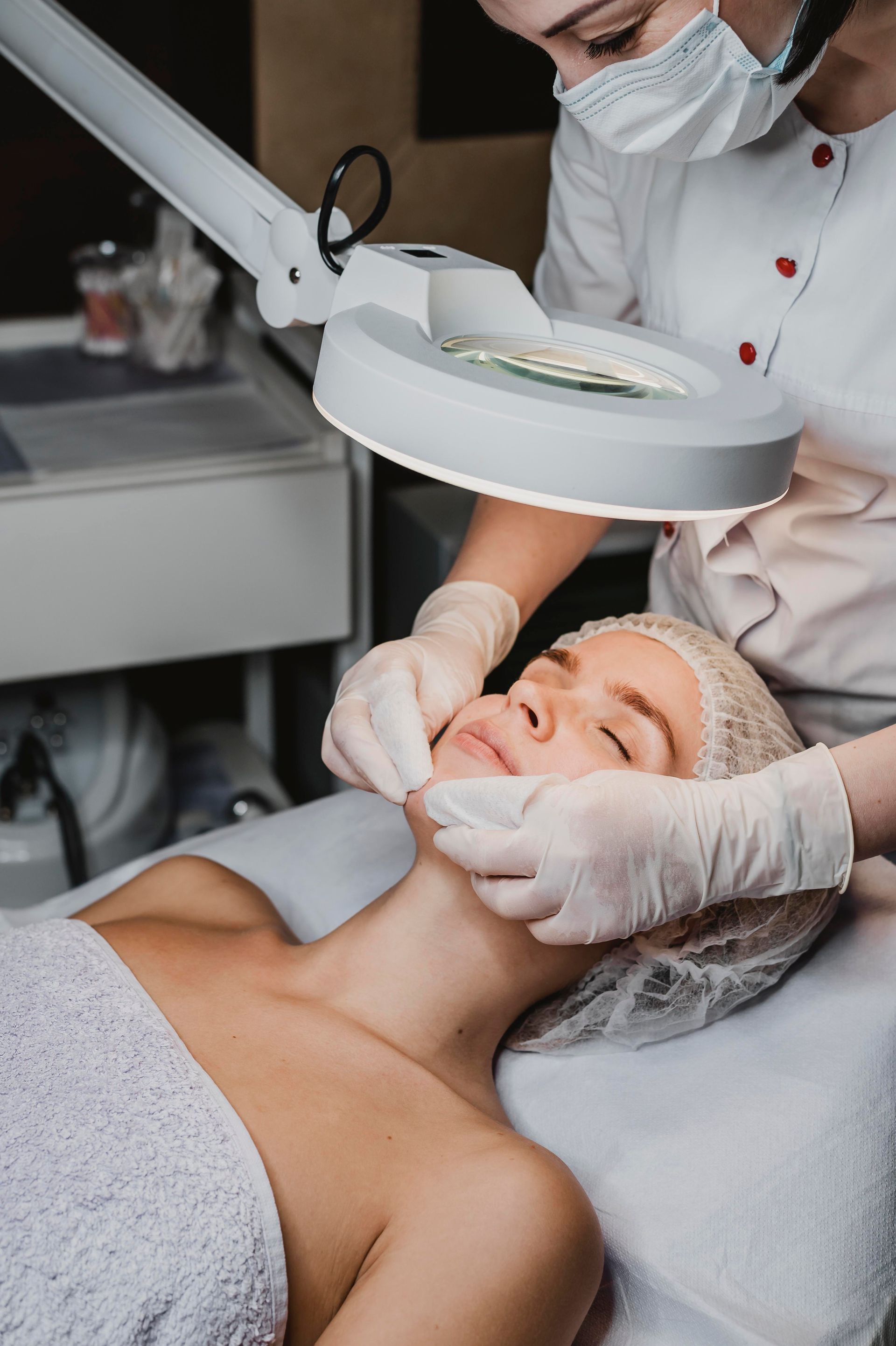 a woman is getting a facial treatment with a magnifying glass