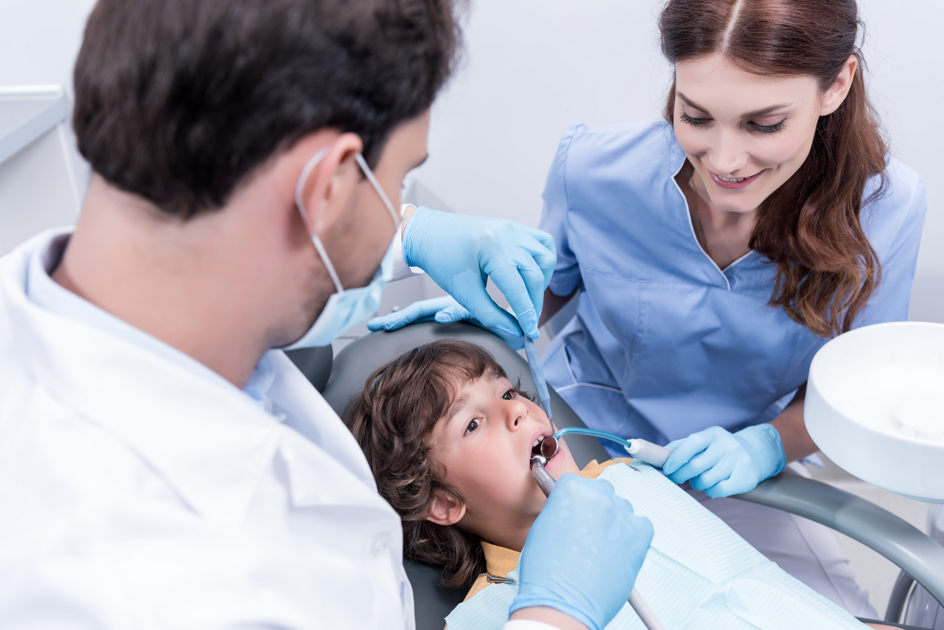A woman is giving a child a high five in a dental office