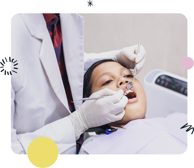 A young boy is getting his teeth examined by a dentist.