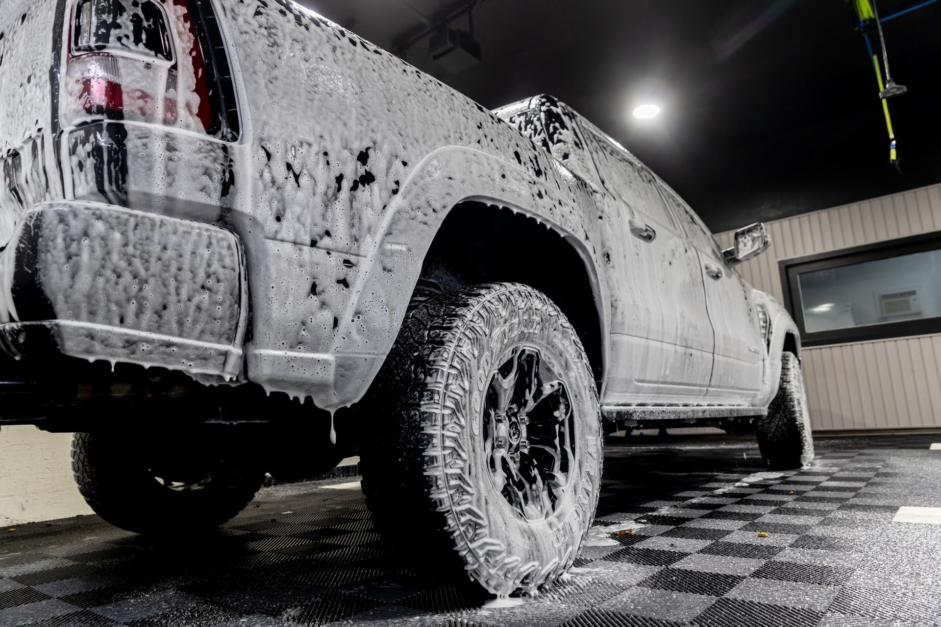 A truck is covered in foam and soap at a car wash.