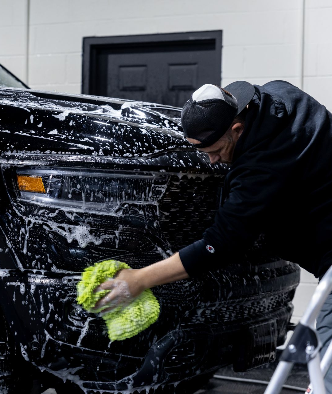 A car is being cleaned in a garage by elevated