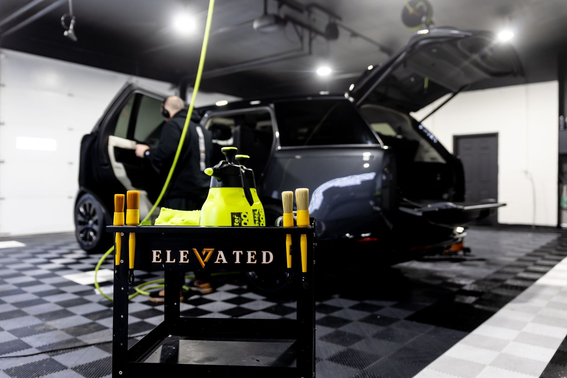 A car is being cleaned in a garage by elevated