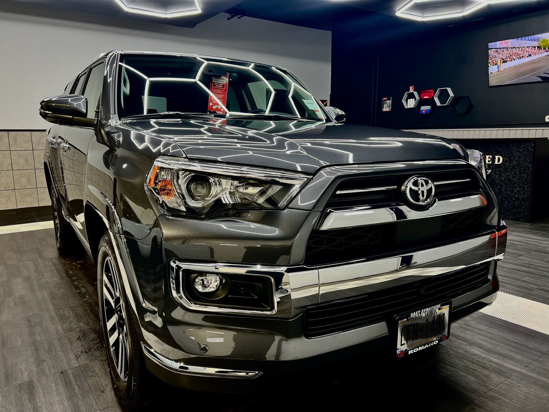 A black toyota 4runner is parked in a garage.