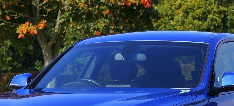 A person is applying tinted glass to a car window.