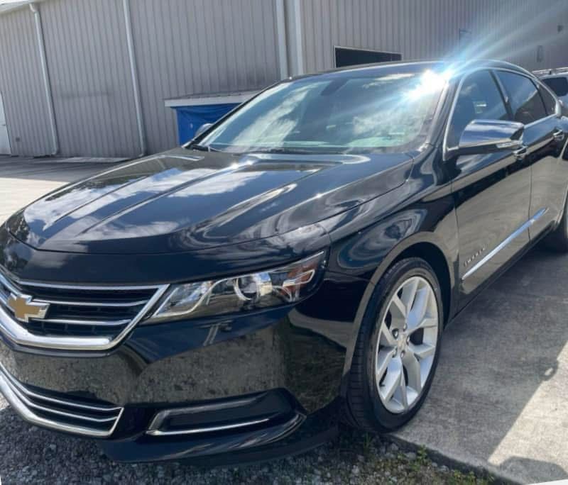Black Chevrolet Impala sedan parked outside on a sunny day.