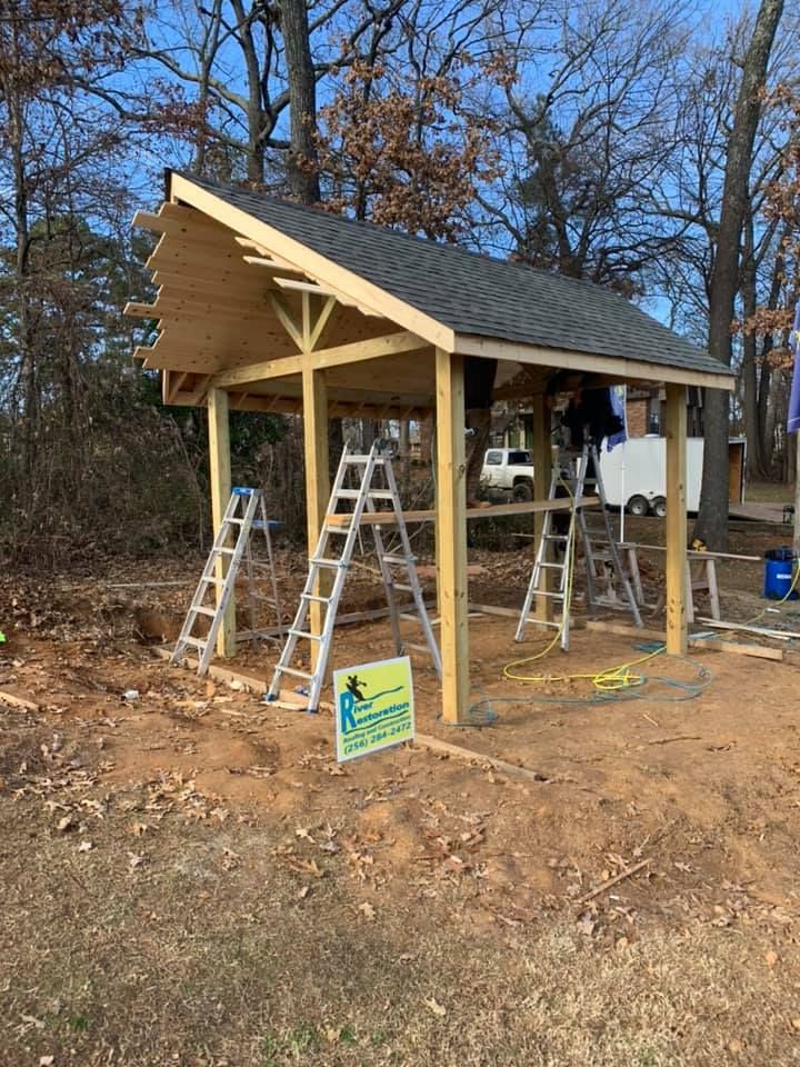 A wooden structure is being built in the middle of a dirt field.