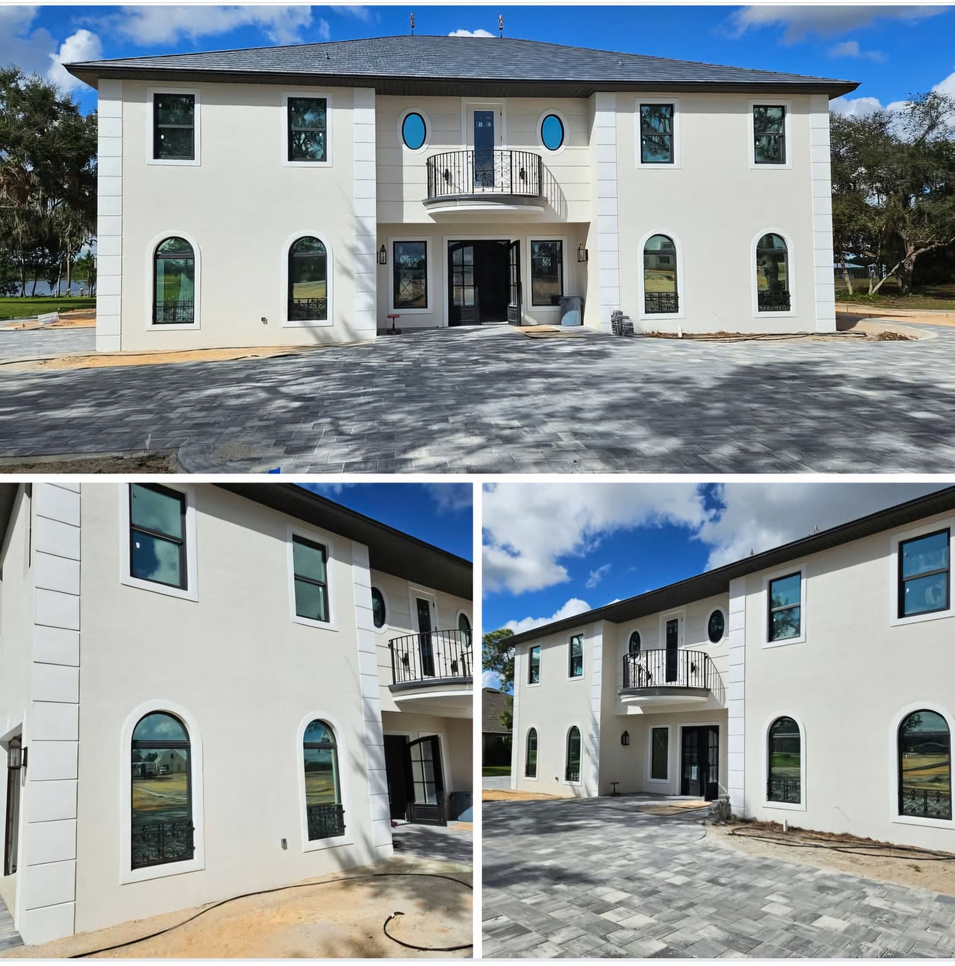 A white house with a black roof and two windows.