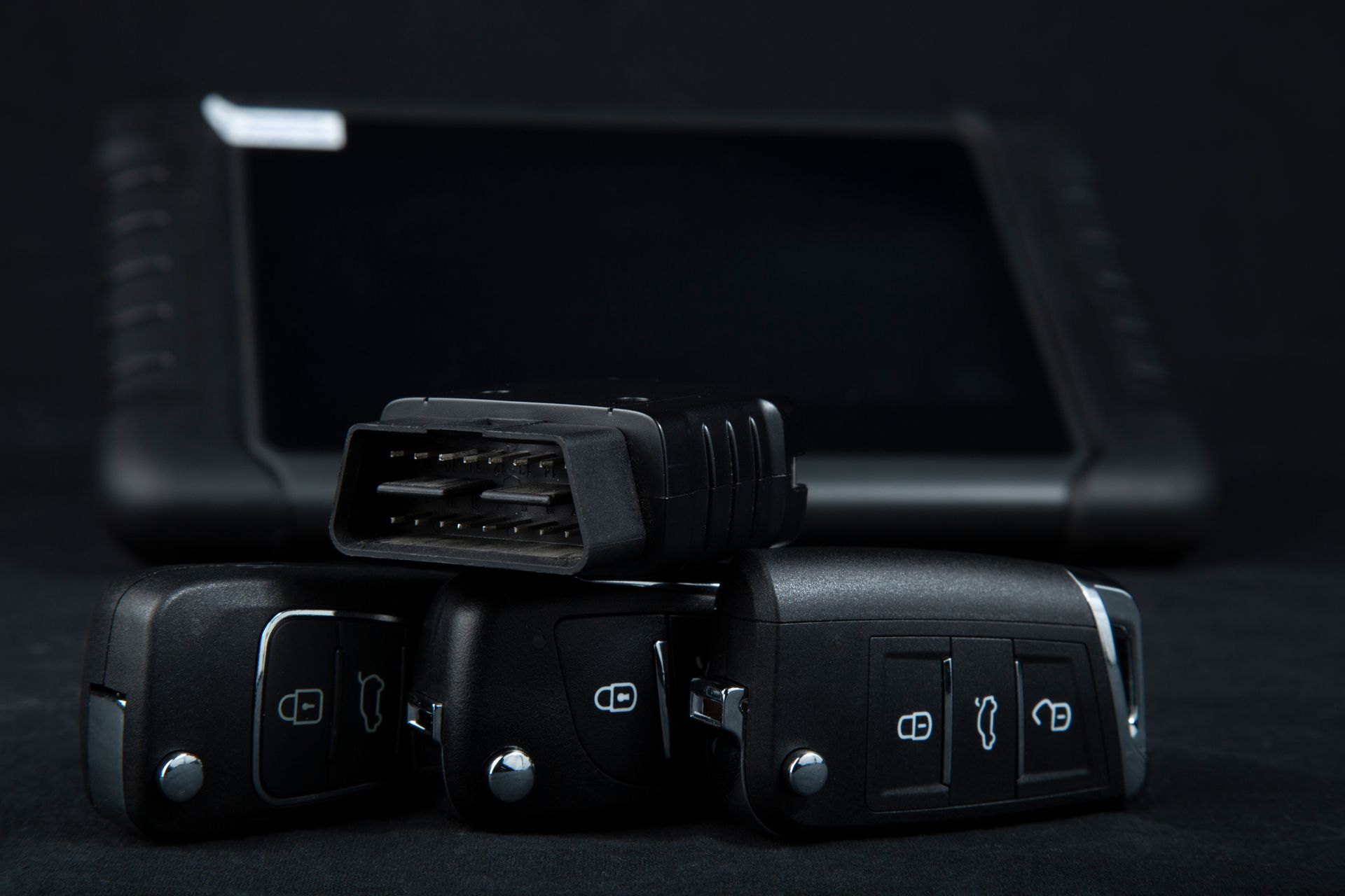 Black electronic connectors arranged in front of a dark tablet screen