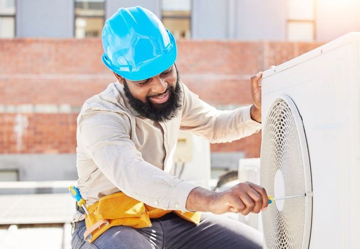 professional electrician man fixing heavy unit