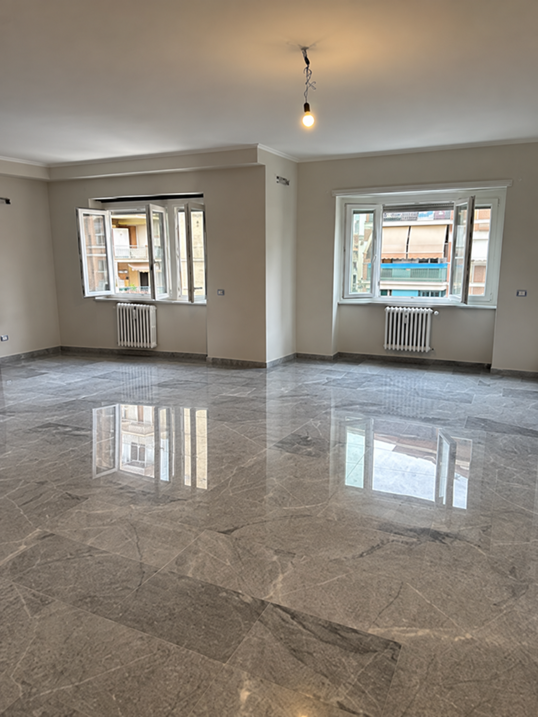 Soggiorno con pavimento in marmo restaurato durante la ristrutturazione completa di un appartamento a Roma San Giovanni