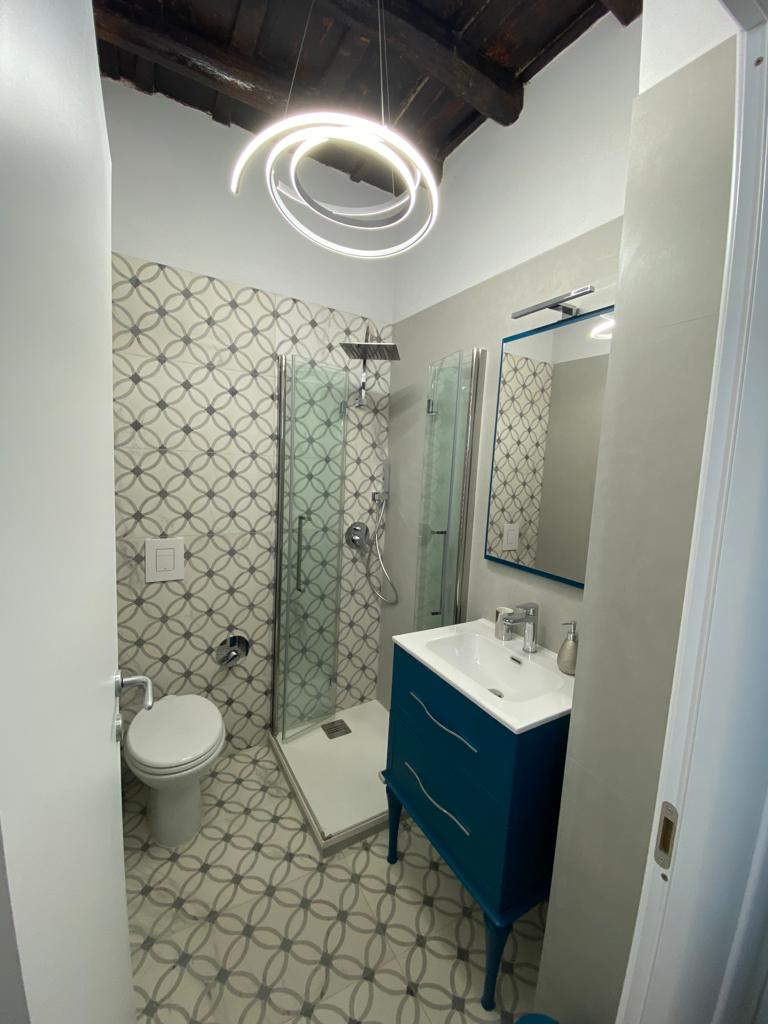 Redistribuzione degli spazi in un appartamento a Roma Trastevere con ampio bagno e cucina moderna.