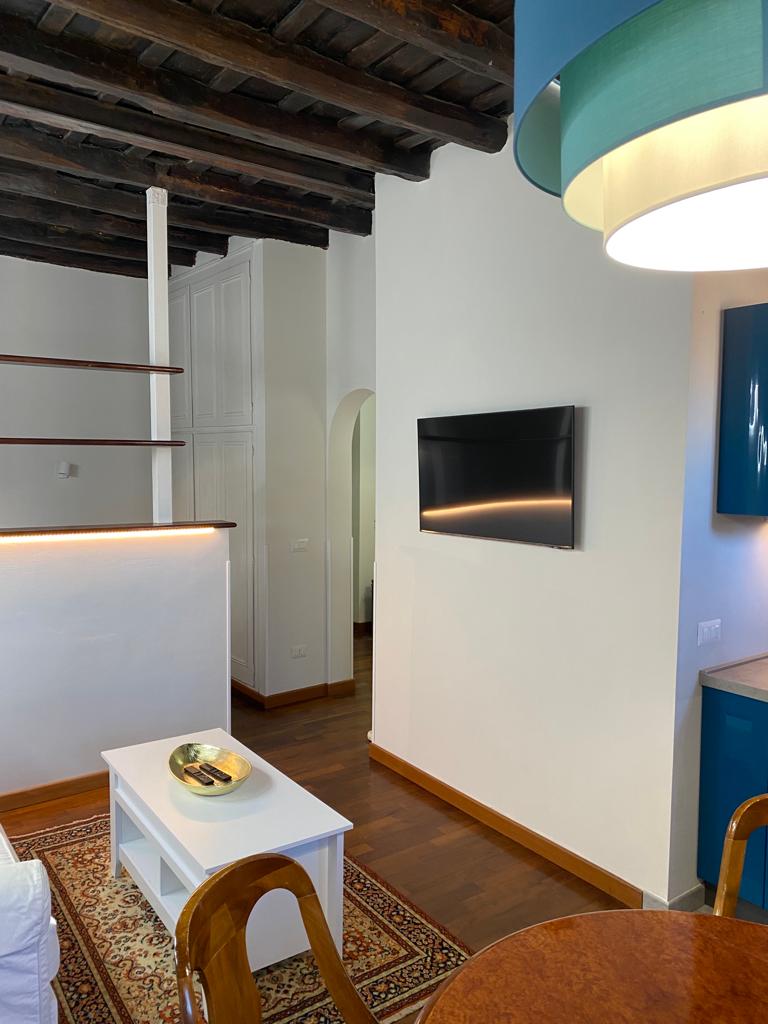 Zona living open space ristrutturata in un appartamento a Roma Trastevere, con design moderno e spazi ottimizzati.