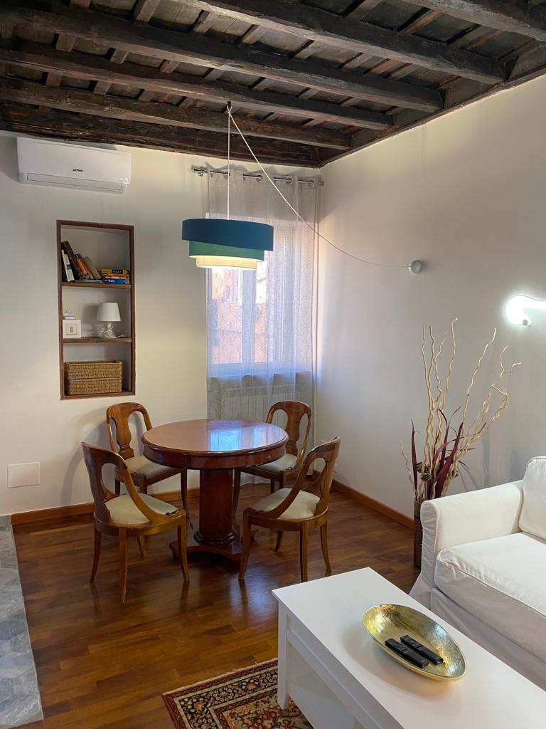 Ingresso di un appartamento ristrutturato a Roma Trastevere con porta in legno massello e dettagli eleganti.