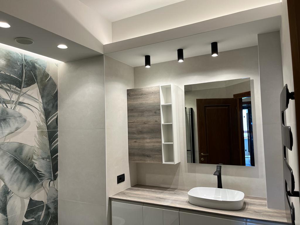 Bagno ristrutturato a Roma Eur con illuminazione moderna e specchio a parete