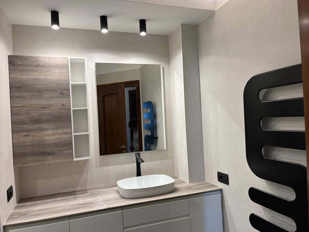 Bagno ristrutturato a Roma EUR con lavandino elegante e specchio a parete per un look moderno.