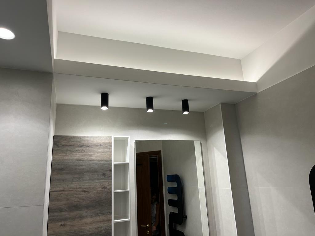 Bagno ristrutturato a Roma Eur con dettagli in pietra e illuminazione soffusa