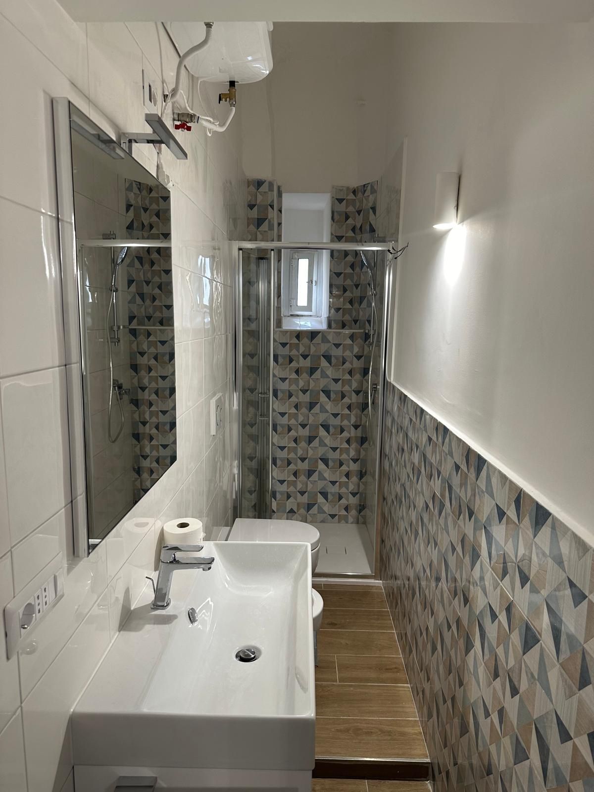 Bagno ristrutturato con sanitari moderni e design minimalista.