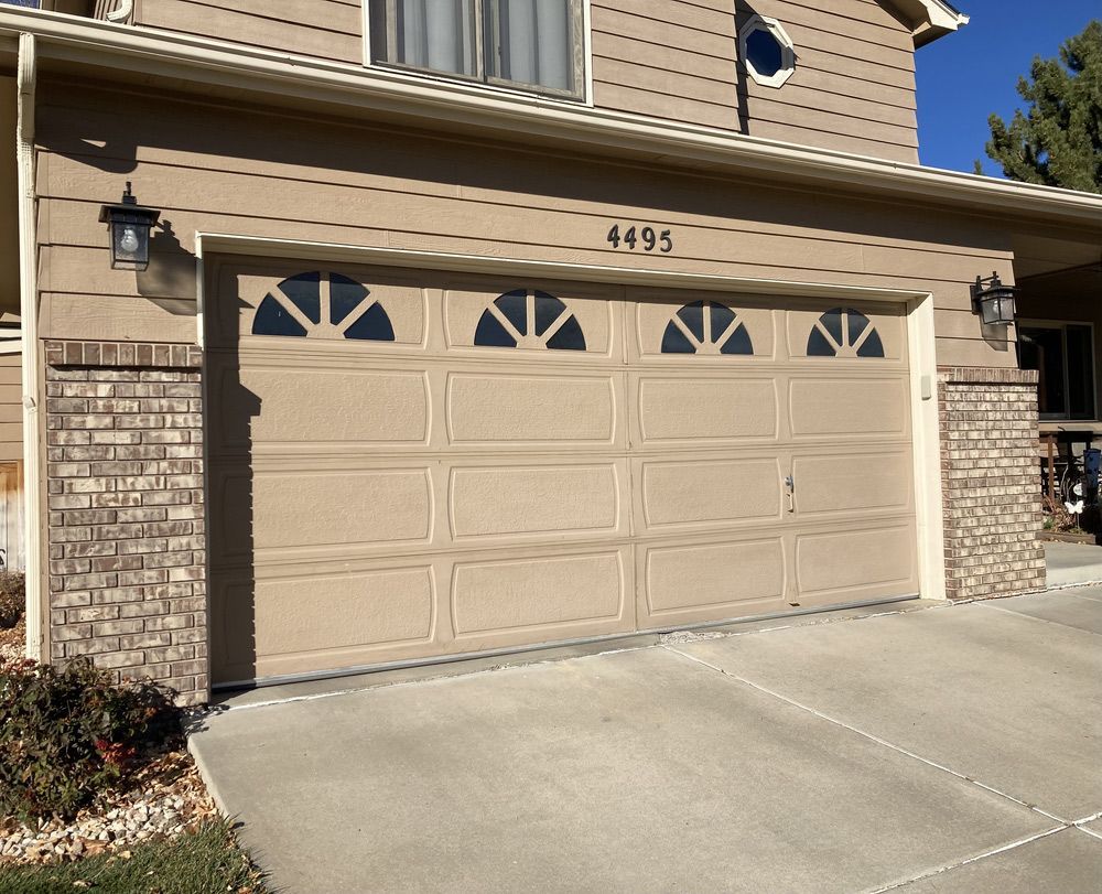 A tan garage door with the number 4495 on it