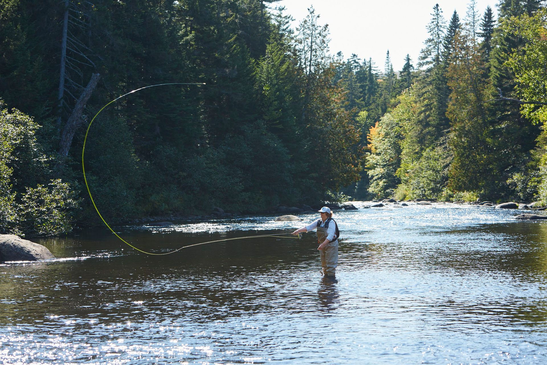 Person standing in a river, fly-fishing