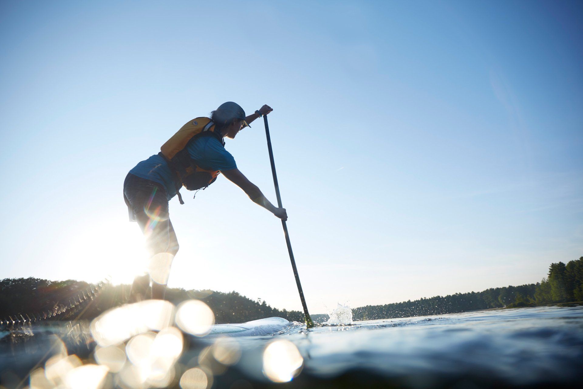Woman paddleboarding bear an island on North Park Lake.