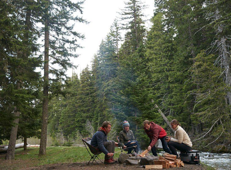 Group sitting in the woods by a campfire