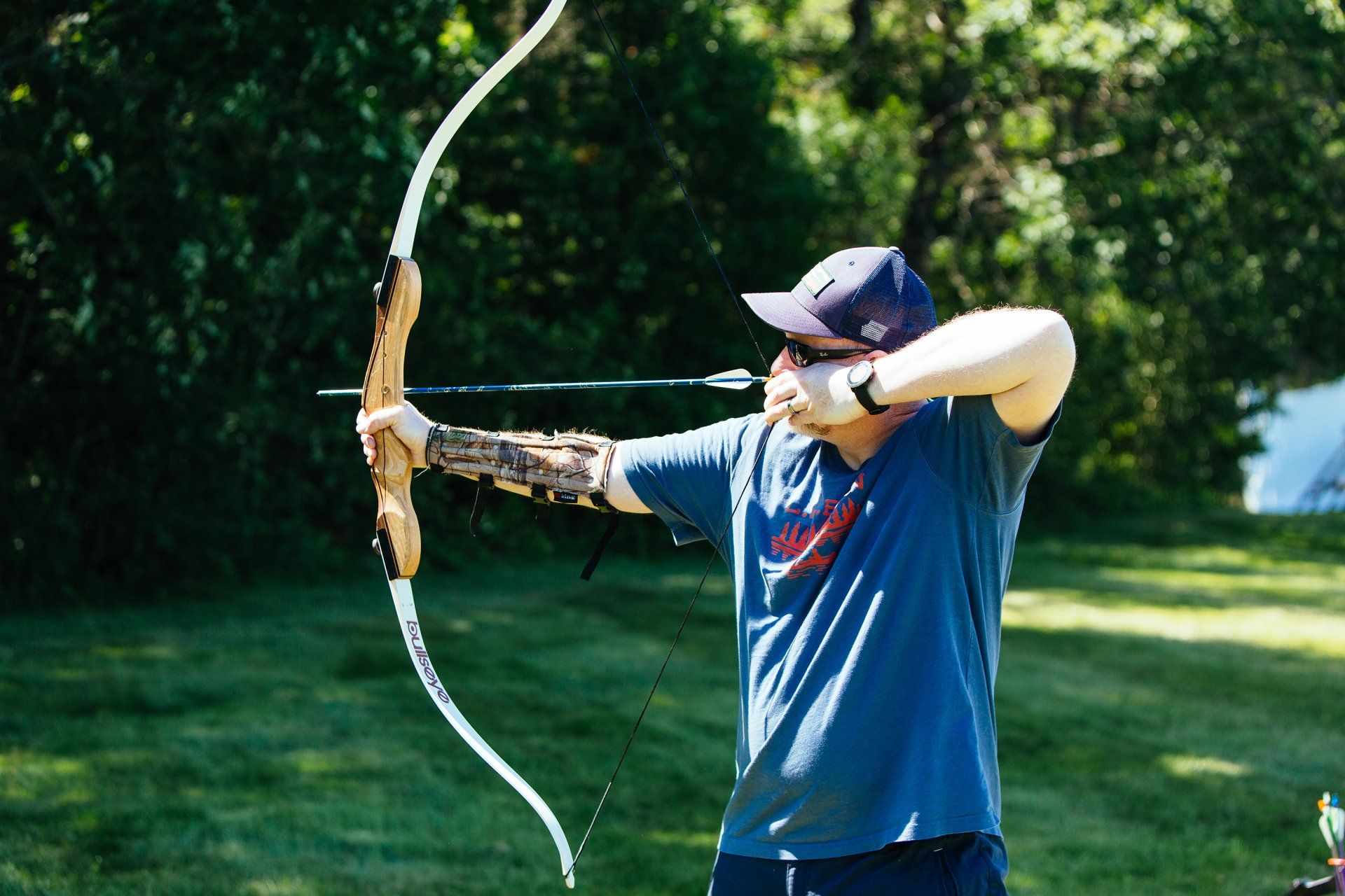a man getting ready to shoot a recurve bow