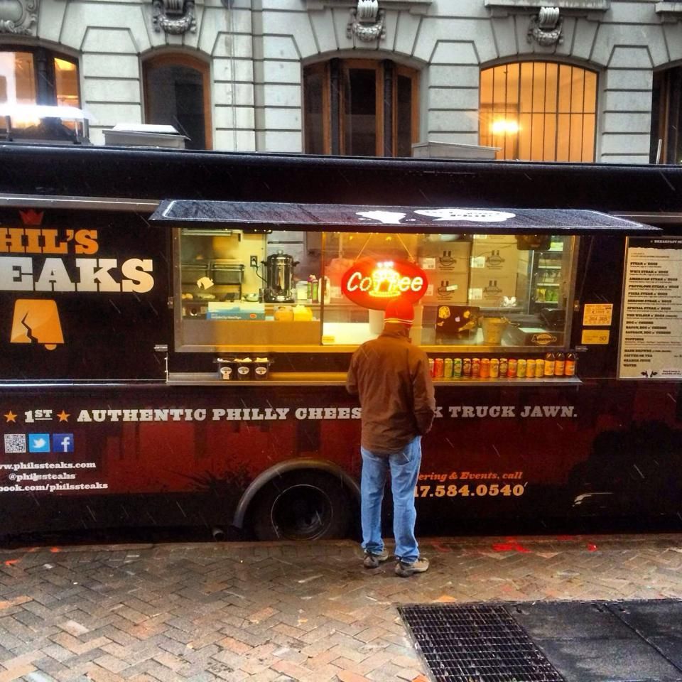 A man stands in front of a phil 's peaks food truck