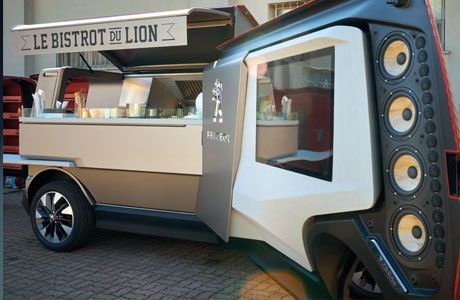 A compact food truck equipped with speakers and a sound system for outdoor events and gatherings.