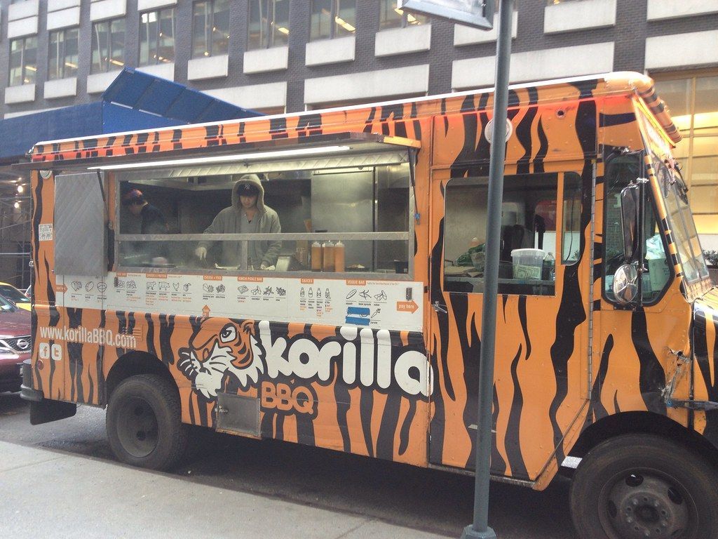 A tiger print food truck is parked on the side of the road
