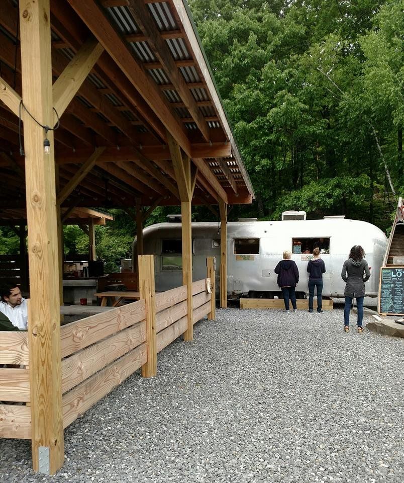 A group of people standing in front of a trailer that says airstream