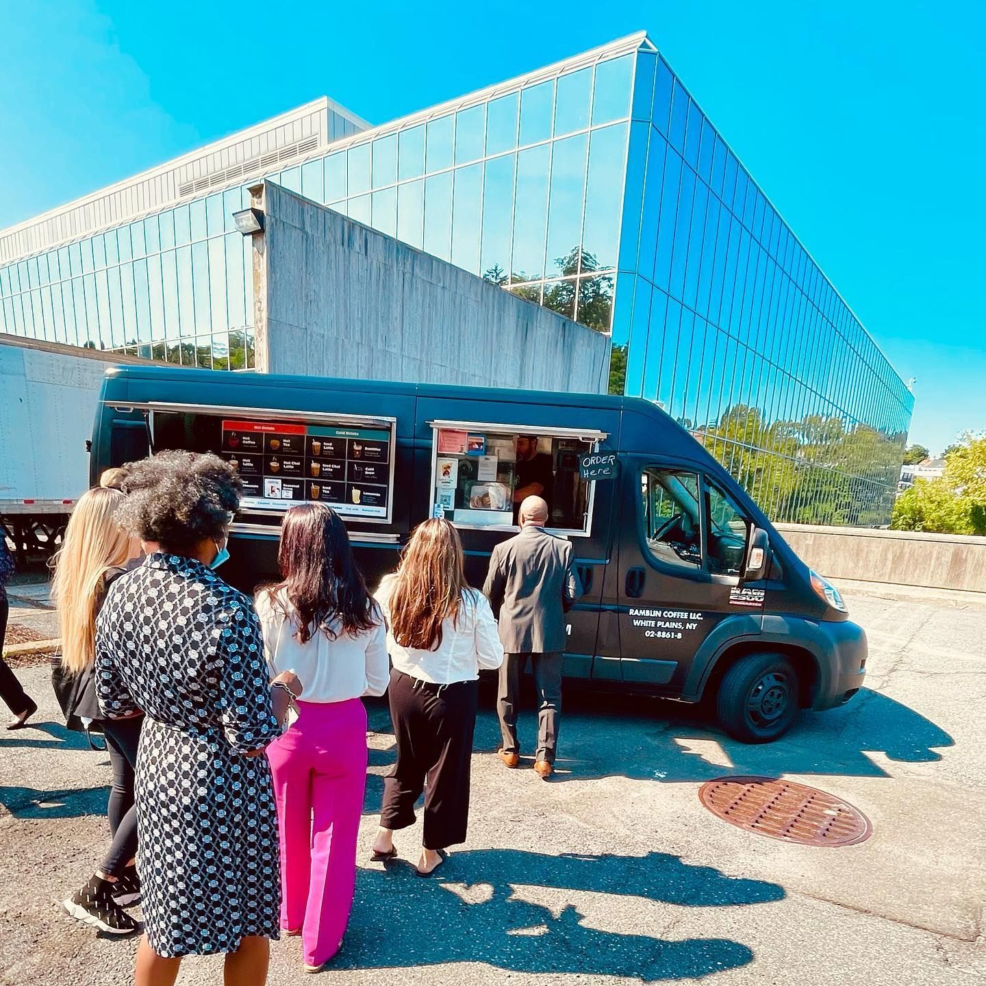 A group of people are standing in front of a food truck.