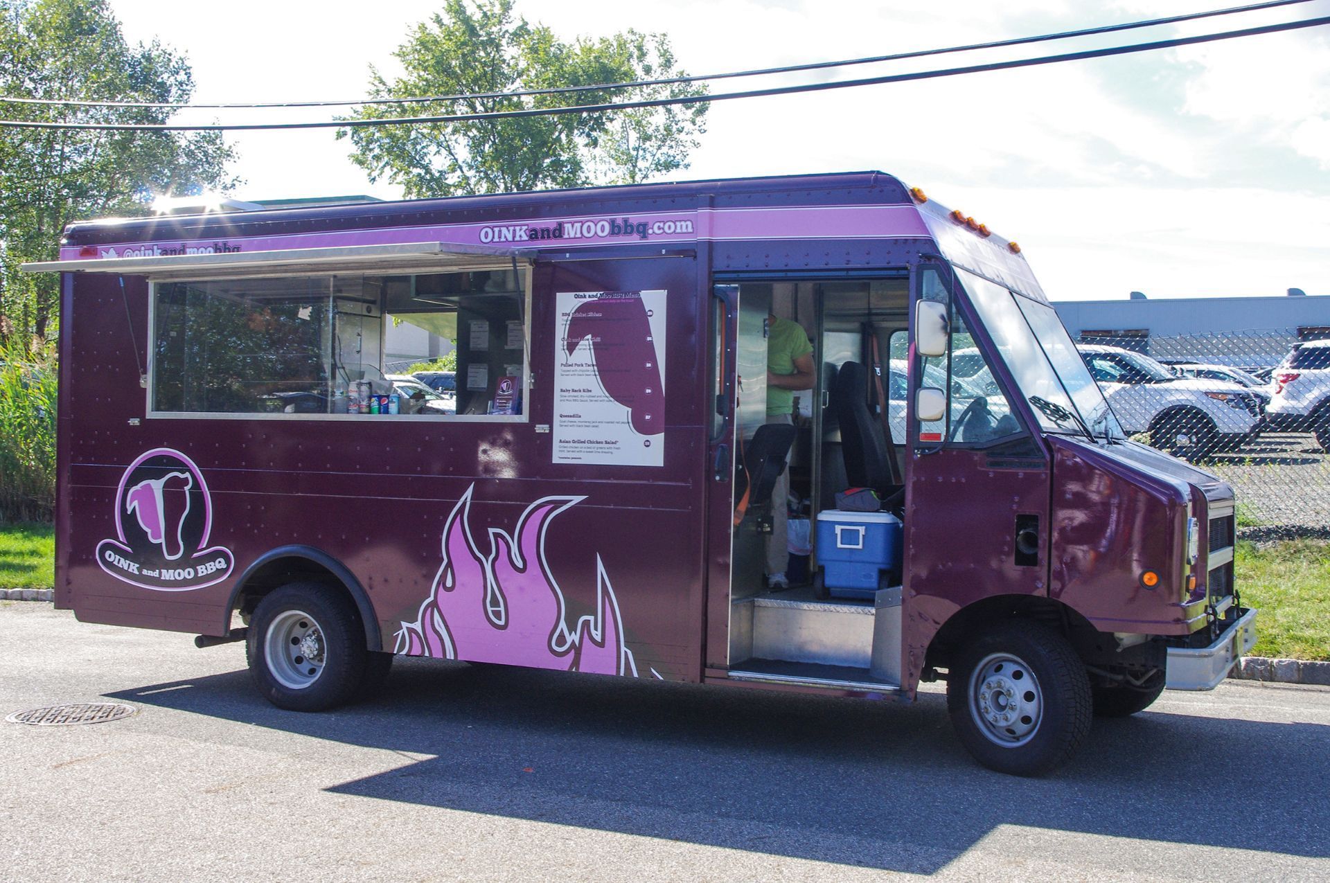 A purple food truck is parked on the side of the road