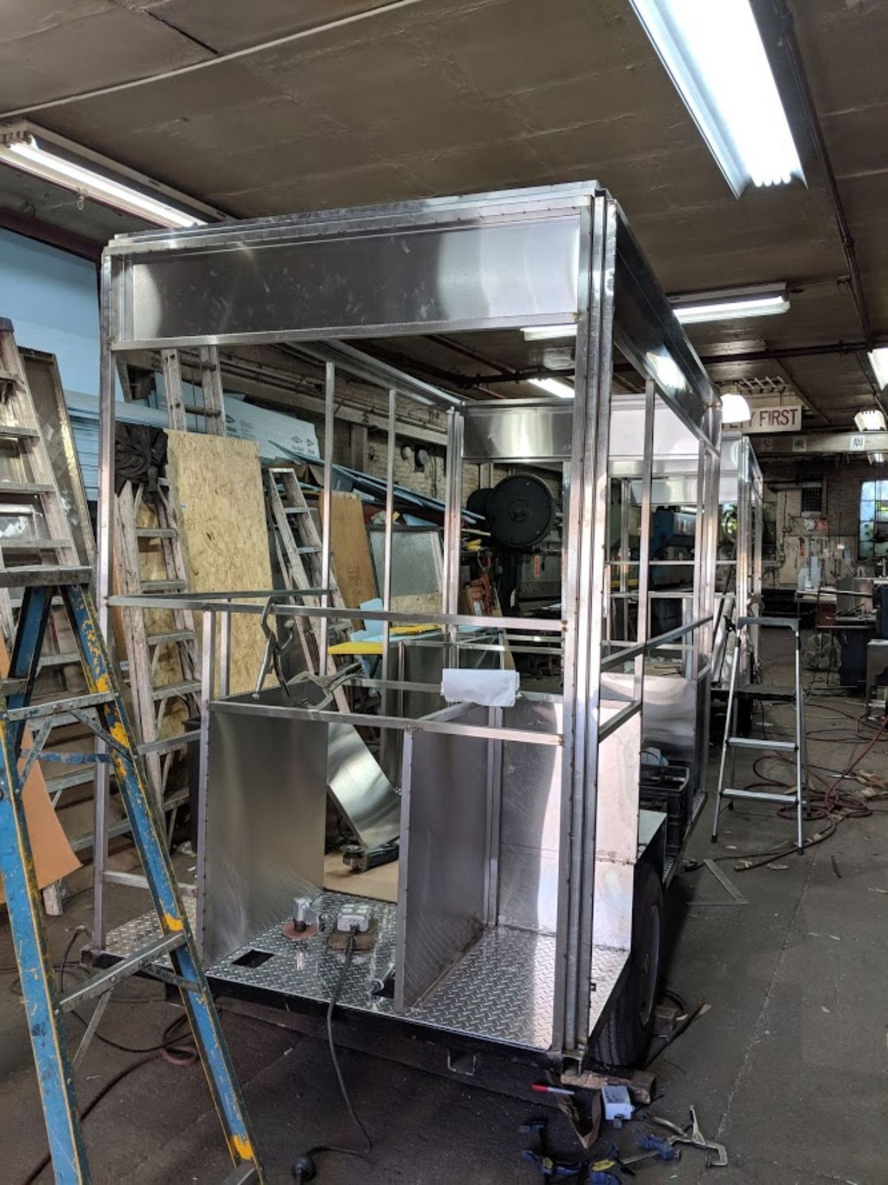 A stainless steel trailer is being built in a factory.