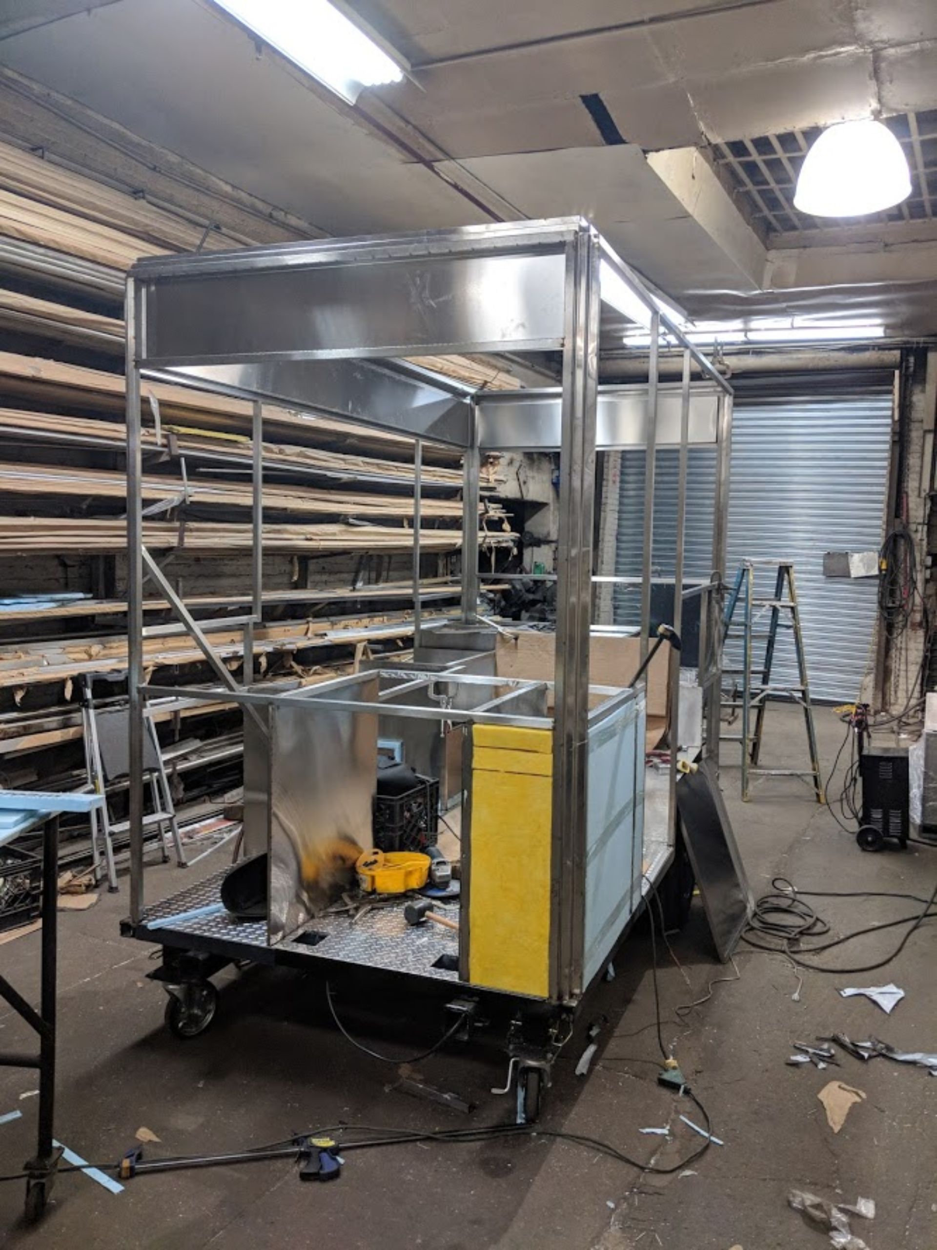 A stainless steel cart is being built in a factory