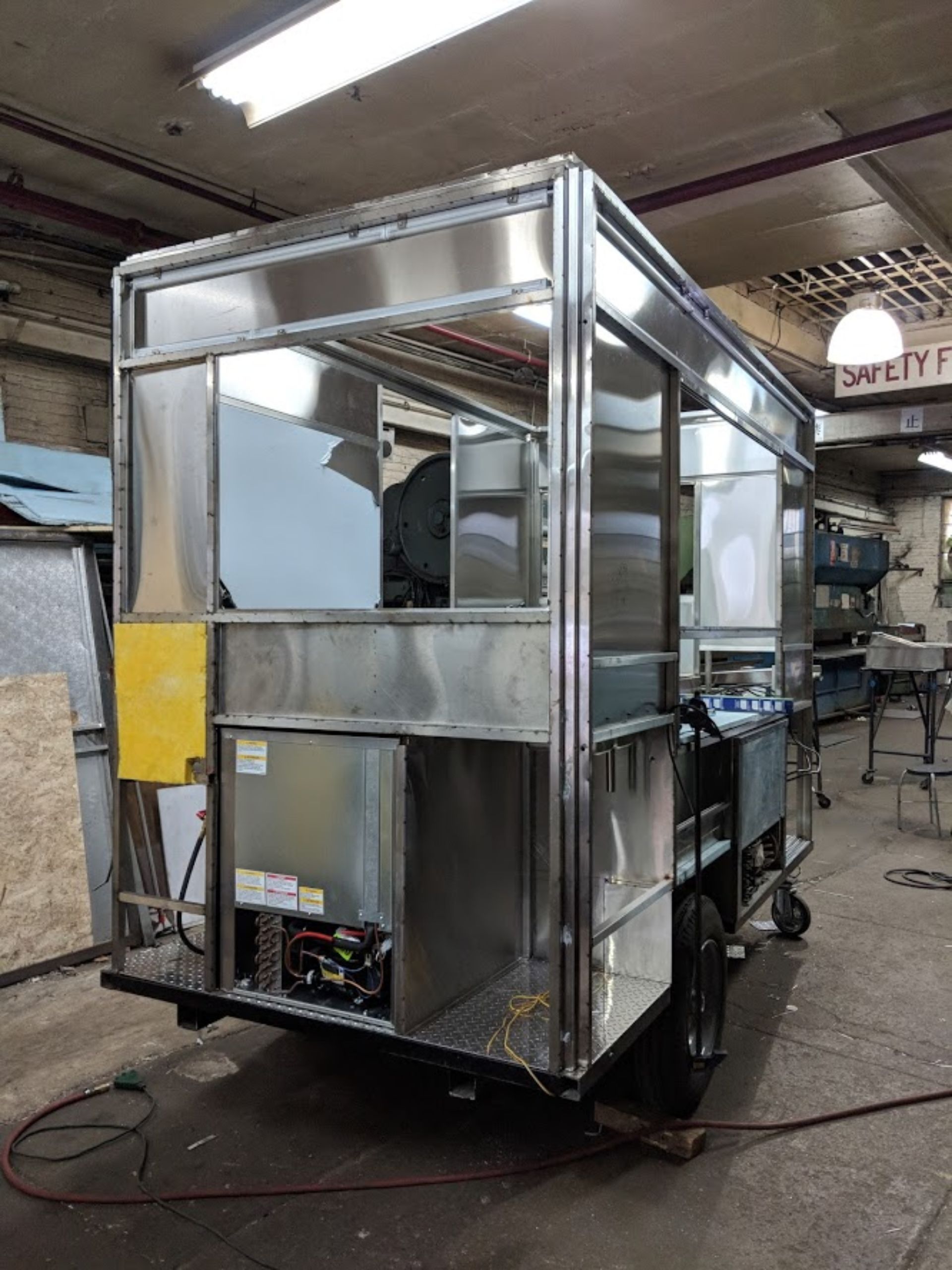 A stainless steel trailer is being built in a factory.