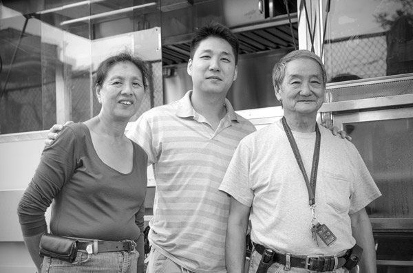 A black and white photo of three people standing next to each other.