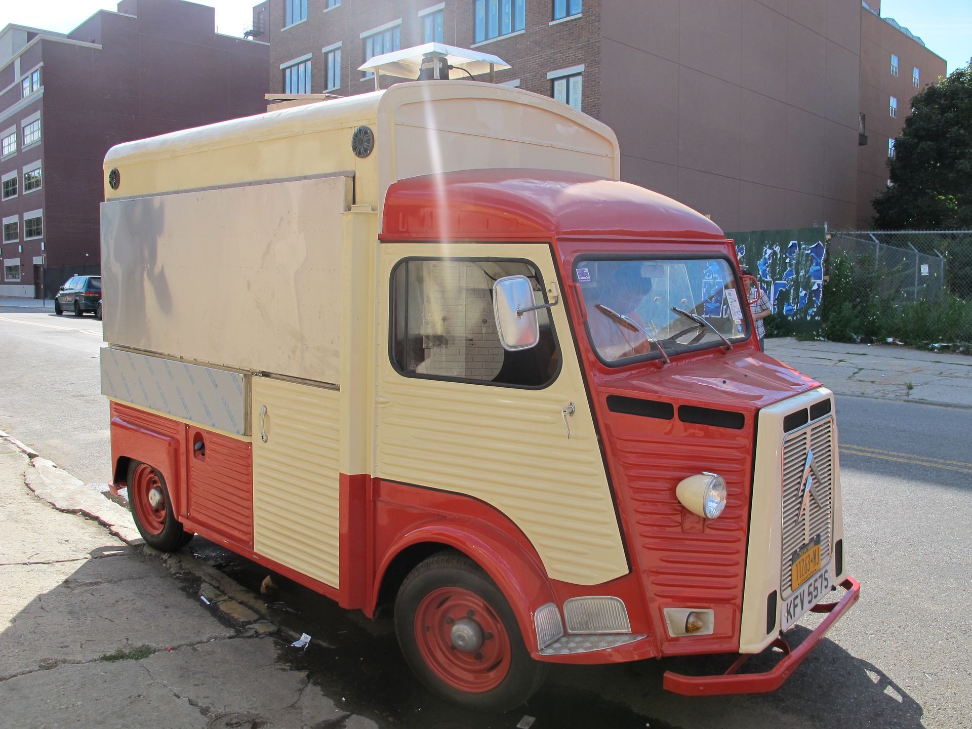 A red and white food truck is parked on the side of the road