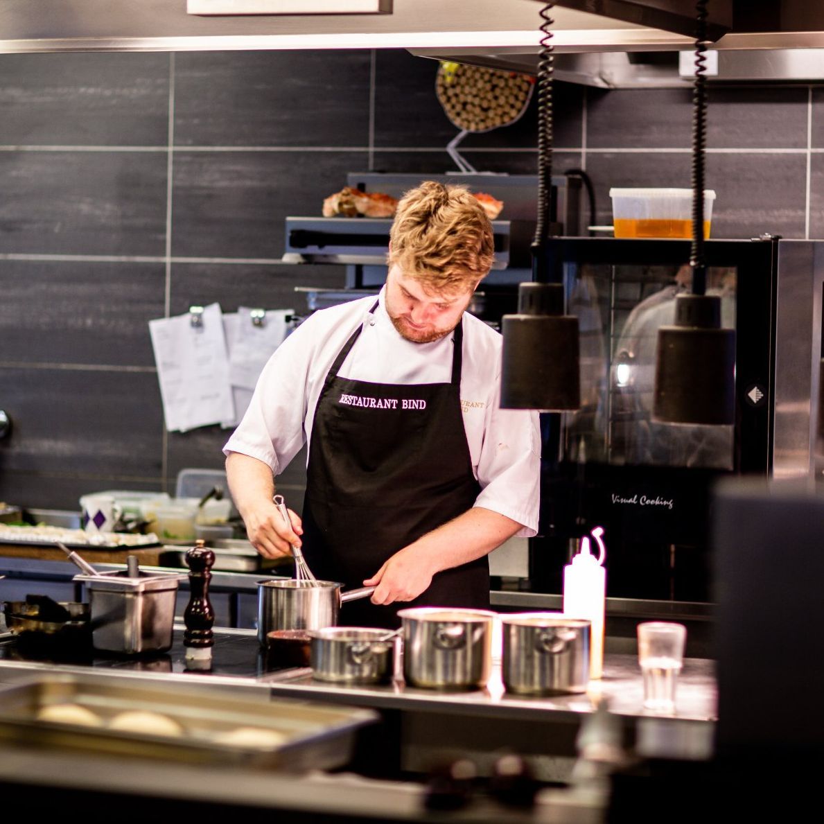 A man wearing an apron that says ' i 'm not a chef ' on it