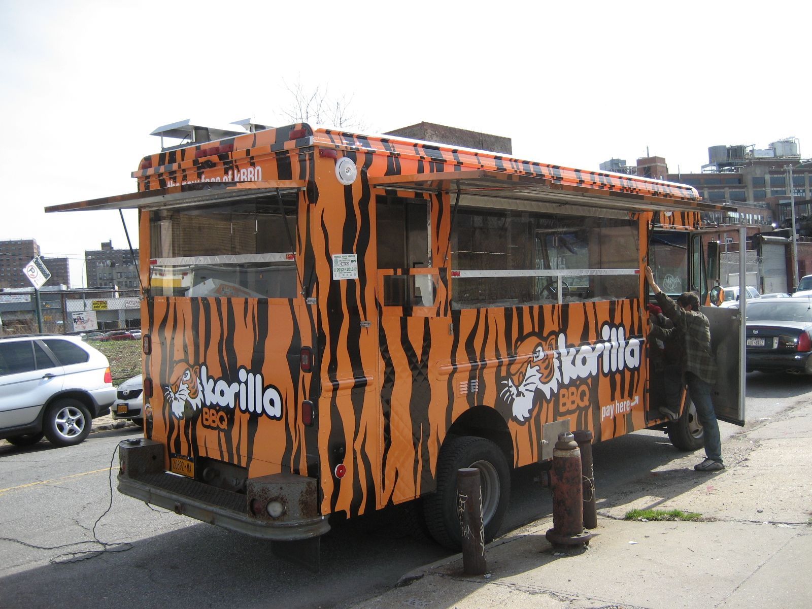A tiger print food truck is parked on the side of the road