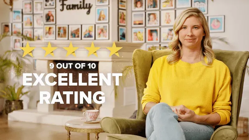 A woman in a yellow sweater is sitting in a chair in front of a fireplace.