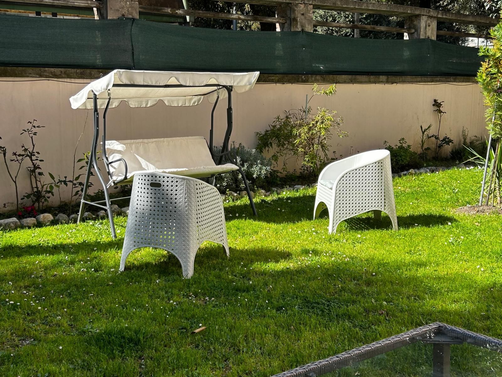 C'è un'altalena e delle sedie sull'erba nel cortile sul retro.