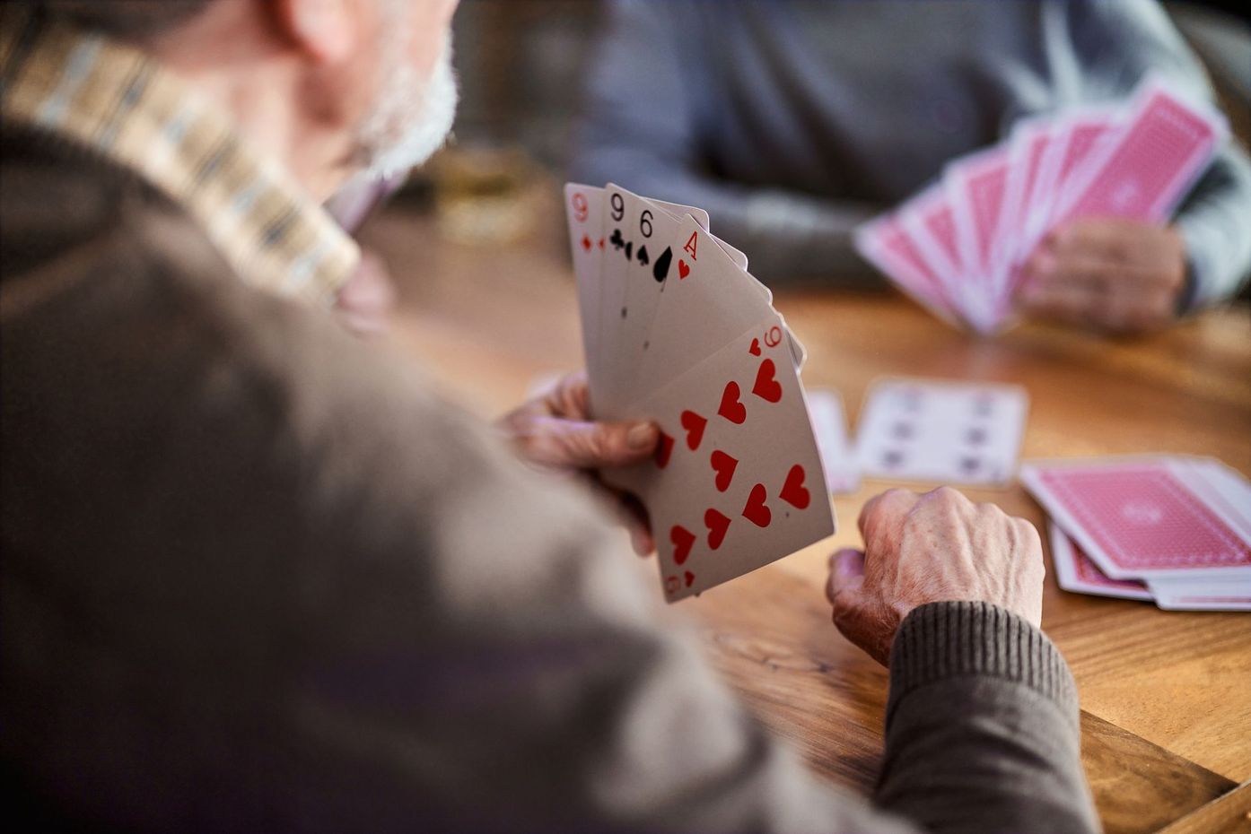 Un gruppo di persone sta giocando a carte a un tavolo.