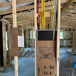 New Build Home Electrical Panel - Palatka, FL - Davis Electric Services LLC Technician Plugging Wires Into A Box On A Wall - Palatka, FL - Davis Electric Services LLC