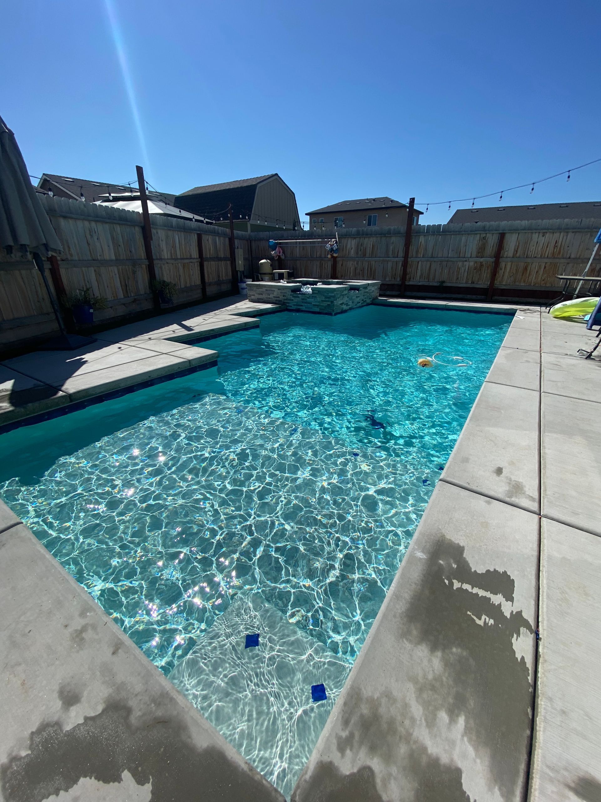 A large swimming pool with a fence in the background