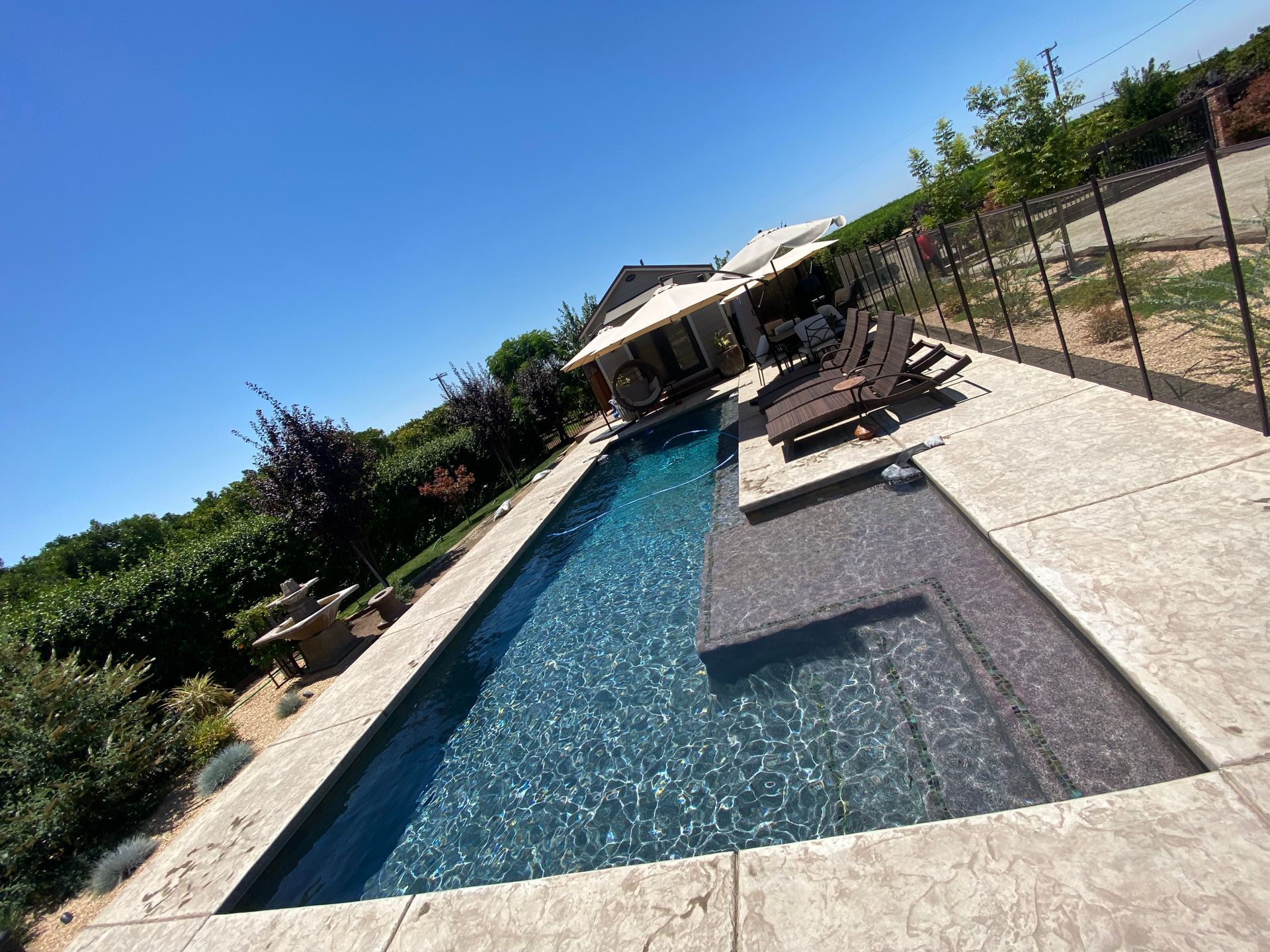 A large swimming pool surrounded by chairs and umbrellas