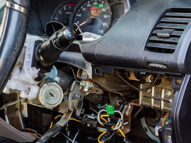 Wiring behind a car dashboard being traced by a car electrician in Coventry