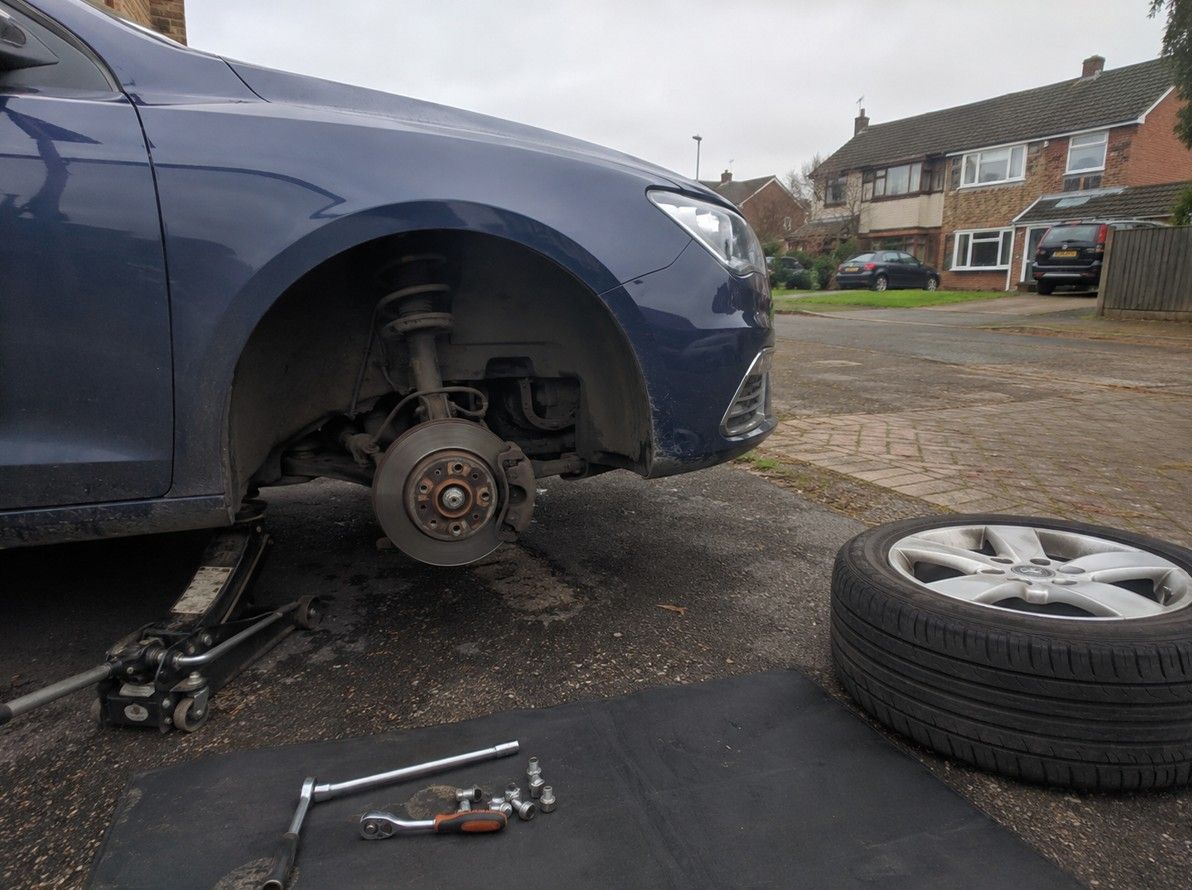 Mobile mechanic carrying out a suspension repair on a car at a residential property in Coventry